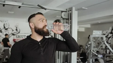 Man drinking water after workout in the gym Stock Footage 56636644