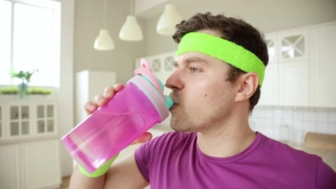 Man is drinking water from bottle after training and pouring his face and body. Stock Footage 132621585