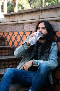 Man drinking water bottle sitting on stairs Stock Photos