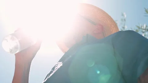 Man Drinking Water In Bright Sunlight Outdoors Wearing  Hat To Stay Hydrated Stock-Footage 340210954