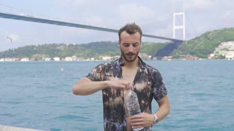 Man drinking water by the sea. Stock Footage 212839192