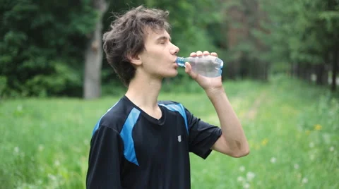 Man drinking water in the summer forest Stock Footage 63931144