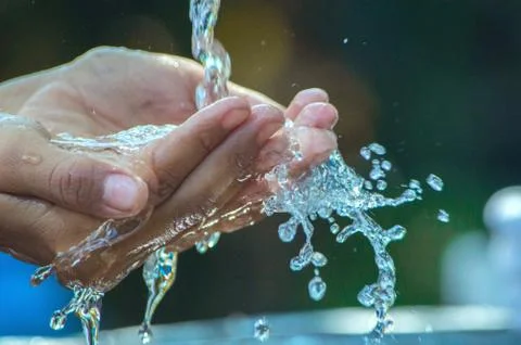 A man is drinking water using his hands Stock Photos