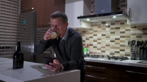 Man Drinking Whiskey and Checking Smartphone at Night. A mid-adult man stan.. Stock Footage 332416039