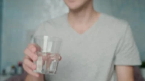 Man drinking white capsule with collagen with glass of water. Nutritional Stock Footage 252040764