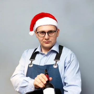 A man is drinking wine in a santa hat Stock Photos