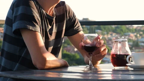 Man drinking wine on terrace of cafe at sunset Vídeos de archivo 256922101