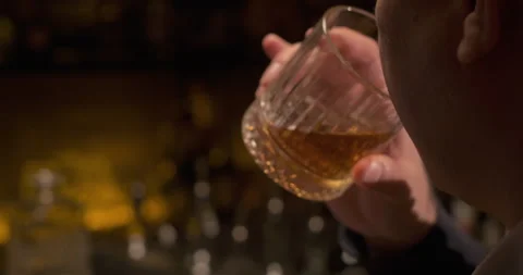 Man drinks alcohol close-up. Glass of whiskey. Enjoy fine alcoholic drinks Stock Footage 257973480