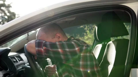 A man drinks alcohol while driving a car. Depression and stress. Stock Footage 252080906