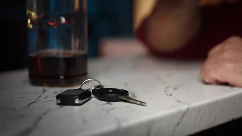 Man drinks alone at bar counter, takes car keys and leaves, DUI awareness Stock Footage 346714171