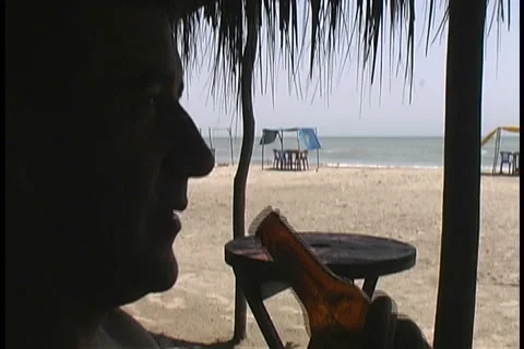 Man Drinks Beer At Beach Stock Footage 1000426