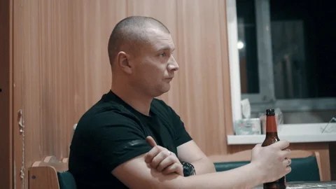 A man drinks beer in the kitchen Stock Footage 100558550