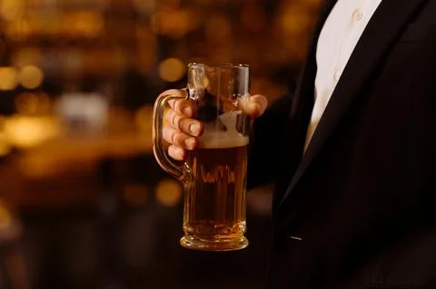 A man drinks beer. Side view of handsome bald man drinking beer in evening pu Foto stock