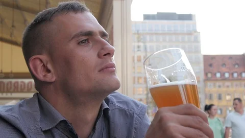 Man drinks Beer sitting at the Table of Street Restaurant in old European City Video stock 94609826