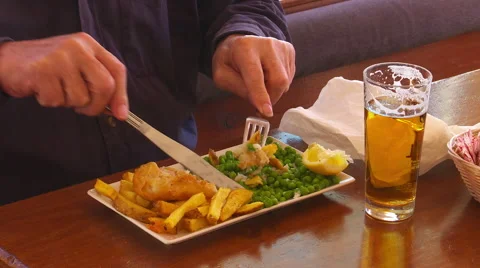 Man drinks beer while enjoying fish and chips  Stock-Footage 48546110