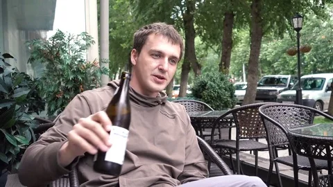 Man drinks from a bottle of cafe on the street Stock Footage 84556903