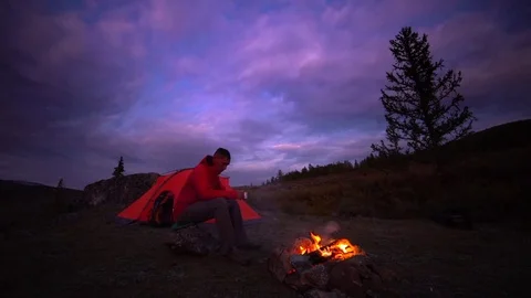 Man drinks at camp fire. Life on travel, evening time Video stock 81321472