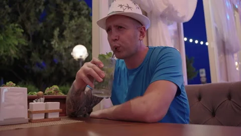 A man drinks a cocktail Stockbeeldmateriaal 199823979