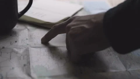 Man Drinks Coffee And Plans Travel Trip On a Map and Notebook 库存影片 142127974