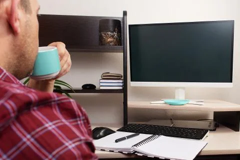 Man drinks coffee at home at the computer Stock Photos