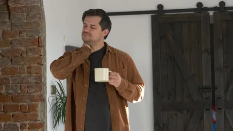 Man drinks coffee at home before starting work at home Stock Footage 141447069