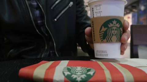 A Man drinks Coffee Starbucks in a Mall Coffee House Point, taking a Paper Cup Stock Footage