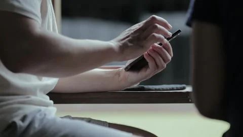A man drinks coffee use his mobile phone on a wooden table by the street Stock Footage 280268215