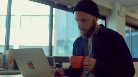Man drinks coffee while working in the startup office Stock Footage 62948144