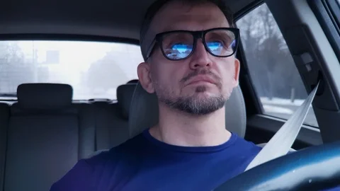 Man drinks coffee from white cup behind steering wheel of moving passenger car Stock Footage 124306861