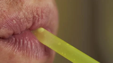 Man drinks a drink through a plastic cocktail tube, close up Stock Footage 144047395