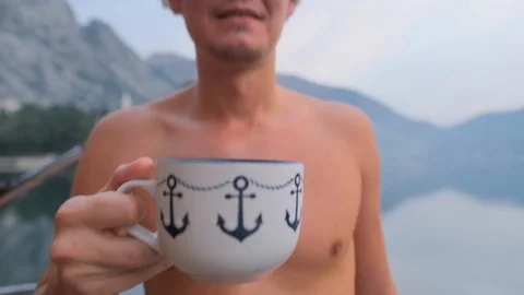 Man drinks herbal tea  on a floating house in the sea Stock Footage 124337585