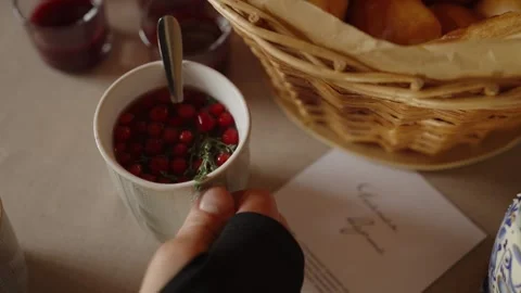 A man drinks hot cranberry tea on a cold day Stock Footage 293896444