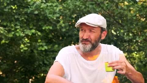 A man drinks hot tea and looks around. Rest in the forest in the summer. Stock Footage 148337869