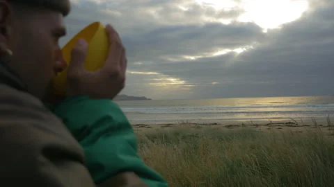 A man drinks hot tea while watching the ocean at sunrise, in New Zealand Stock Footage 219236907