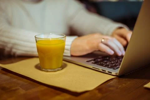 Man drinks juse while working on laptop Foto stock