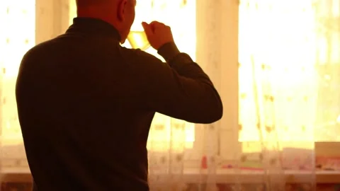 Man drinks morning coffee at the window Stock Footage 150863149