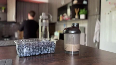 Man drinks protein shake after workout in home kitchen Stock Footage 313831228