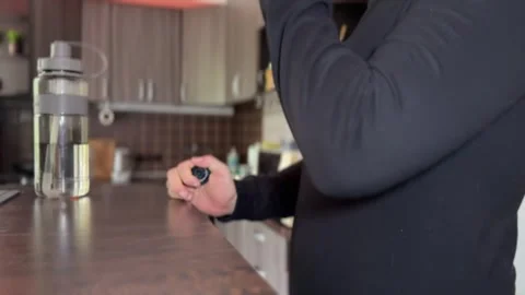 Man drinks protein shake in dark kitchen, close-up shot Stock-Footage 313831199