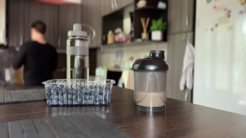 Man drinks protein shake with milk in home kitchen Stock Footage 313831222
