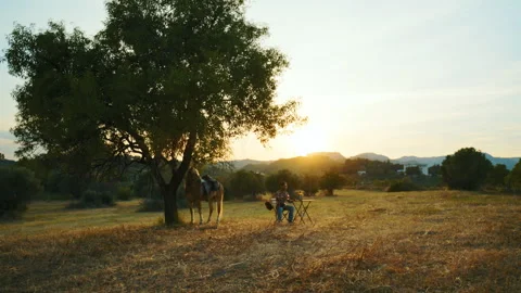 A man drinks a soft drink during a break in the countryside at sunset in Italy Stock Footage 336905234