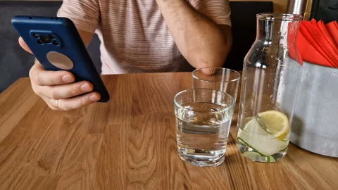 A man drinks tea and uses a mobile phone app for online business communication. Stock Footage 243167558