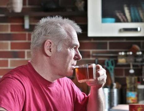 A man drinks tea in the kitchen Stock Photos