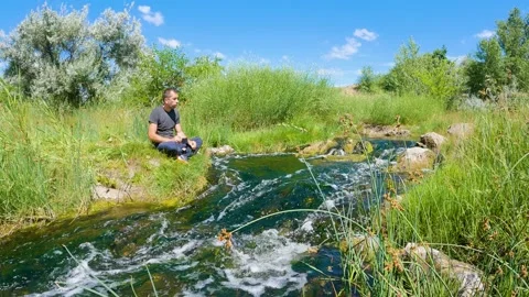 A man drinks tea in nature by the river. Peace of mind and enjoyment of life Stock-Footage 199192327