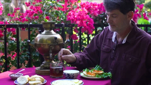 Man drinks tea from samovar with caviar and food on table Stock Footage 201501573