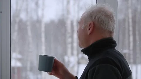 A man drinks tea standing by the window Stock Footage 167148348