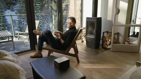 A man drinks tea while contemplating the winter forest through the window Stock Footage 265104468