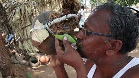 Man-drinks-toddy-from-a-clay-pot-using-leaf Stock Footage 109253700