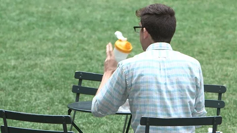 A man drinks water at Brian Park, New York City, Manhattan Vídeos de archivo 128453797