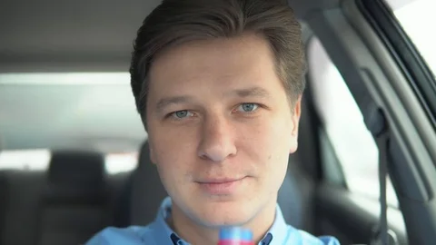 A man drinks water in a car. Stock Footage 81822456