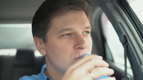 A man drinks water in a car. Stock Footage 81824196